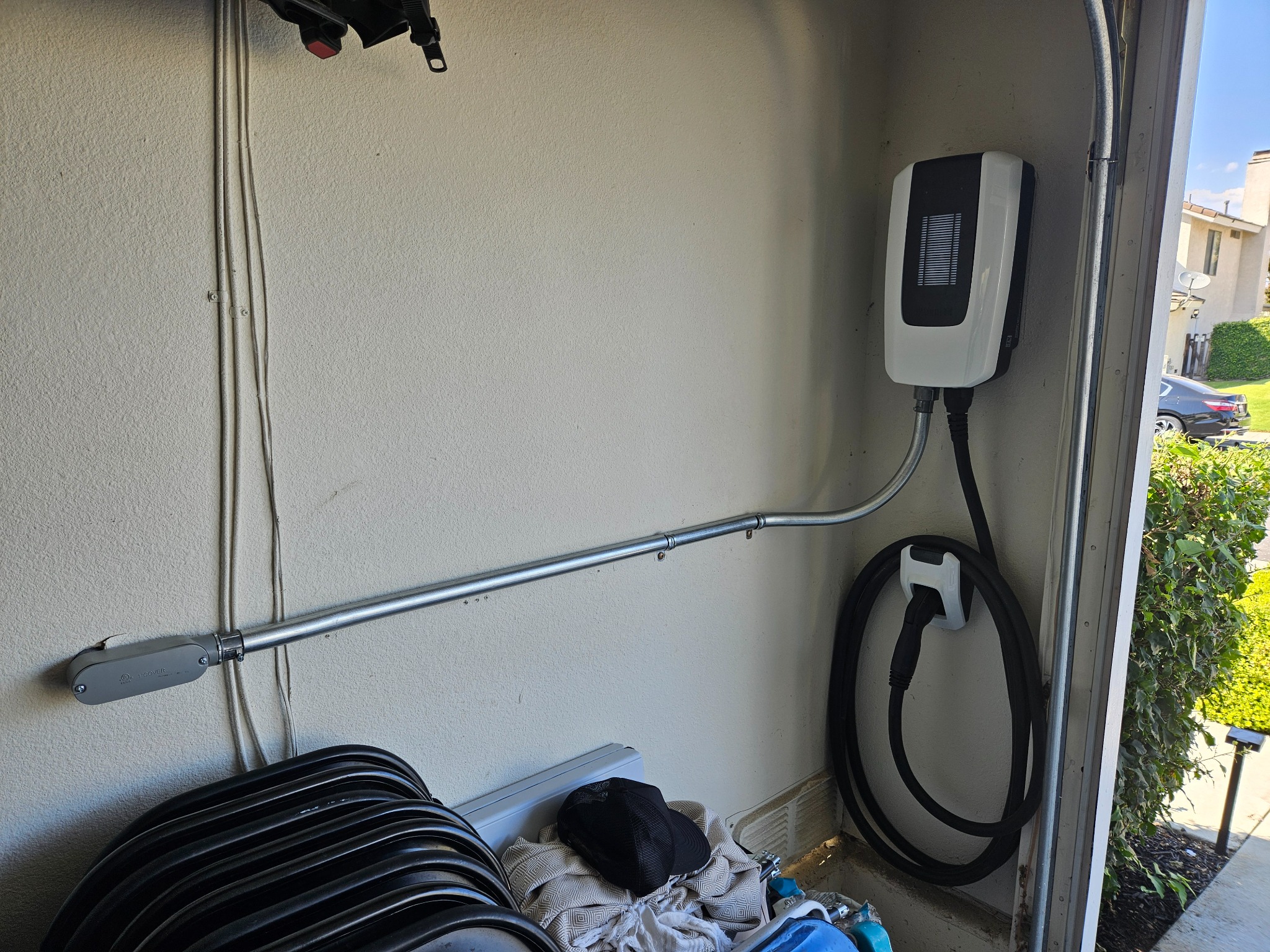 Residential Level 2 EV charger installed in garage with clean conduit routing